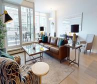 The Anchorage - Modern furnished apartment in Dartmouth featuring bright living room, leather sofa, large TV, and dining area - Premiere Suites