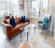 Hintonburg Connection - Ottawa fully furnished apartment living room with brown leather couch and glass coffee table - Premiere Suites