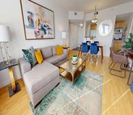 Assomption - Moncton serviced apartment comfortable living room with grey sofa with yellow pillows and living room - Premiere Suites