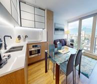 Pendrell - Vancouver short-term rental apartment dining room with glass table and grey chairs - Premiere Suites