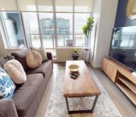 Maple Commercial - Halifax executive suites living room with brown couch and wood coffee table - Premiere Suites Hollis Street