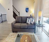 Rockcliffe Village - Ottawa fully furnished townhouse open concept living room with grey couch - Premiere Suites
