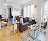 Assomption - Fully furnished monthly rental in Moncton living room with grey sofa and glass coffee table - Premiere Suites