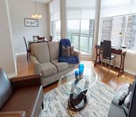 The Laurier - Ottawa fully furnished apartment living room with grey couch and glass coffee table - Premiere Suites