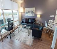 Westboro Connection 2 - Ottawa furnished apartment living room with black leather couch and purple accent wall - Premiere Suites