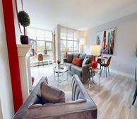 Bishops Landing LW77 - Halifax furnished family-friendly apartment living room with grey couch, grey armchairs and red accent wall - Premiere Suites